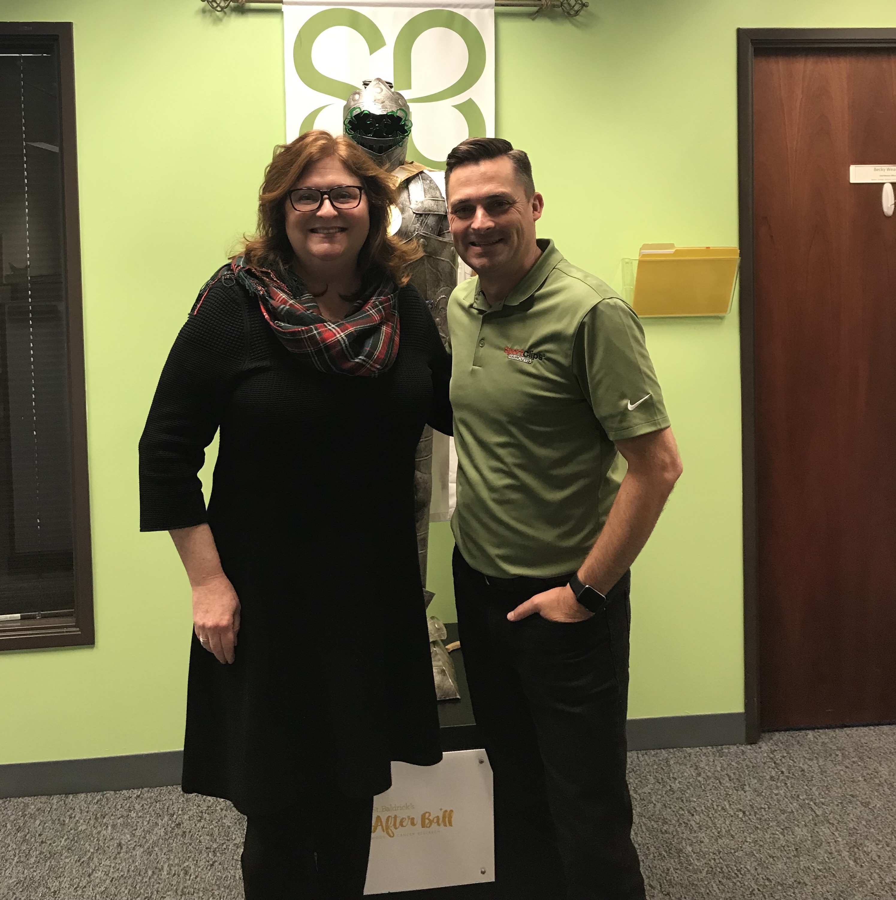 Kathleen and Chad holding a microphone at St. Baldrick's Headquarters